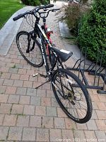 Rear-right three-quarter view of entire bike on paving stones