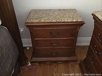Front perspective of the night table showing all three drawers, granite top, and wooden frame.