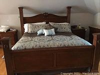 Full front view of custom king bed with bedding on it showing headboard and footboard design.