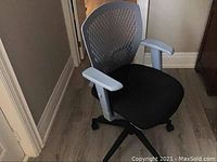 Fabric and resin office chair with a black fabric seat and light gray resin mesh backrest and armrests on a black base with caster wheels, shown from front and side angles.
