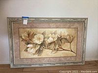 Front view of shabby chic framed floral artwork with white flowers and green leaves on a branch.