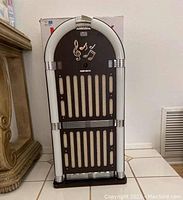 Front view of Magnavox jukebox style speaker system in dark wood with white light tubes and musical note decorations