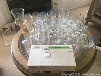 Silver tray holding various clear glassware including wine glasses, small wine glasses, small pitchers, and boxed set of 4 Libbey glasses.