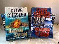 Front cover of Havana Storm and Treasure of Khan hardcover novels by Clive Cussler and Dirk Cussler