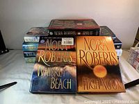Front covers and arrangement of Nora Roberts books including 'Whiskey Beach' and 'High Noon' prominently visible on top