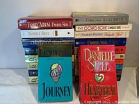 Stack of 12 Danielle Steel novels showing front covers and spines with visible titles Family Album, Journey, Heartbeat, and others.