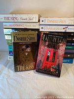 Photo showing stacks of Danielle Steel paperback novels including "The Kiss" and "Charles Street"