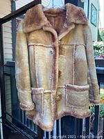 Full view of vintage men's suede leather coat showing shearling lining and large pockets