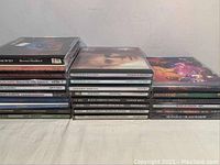 Top view of stacked CD cases showing various titles and artists.