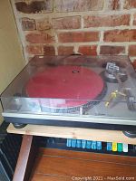 Technics SL-1200MK2 turntable with closed dust cover showing red platter mat
