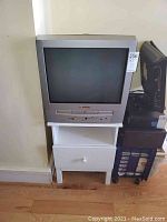 Front view of a silver Sylvania CRT TV with integral DVD player, showing the screen and control panel.