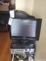 Front view of black Toshiba CRT TV/DVD combo unit with 22-inch screen, power/operational buttons visible at the bottom.