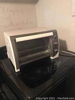 Front and side angles of Black & Decker toaster oven showing the control knobs, glass door, and ventilation slots.
