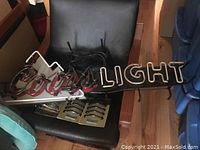 Full view of the Coors Light neon sign showcasing the 'Coors' script and 'LIGHT' block letters with electrical cord attached.