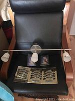Photo showing the 20 inch ceiling accent light fixture with three frosted glass shades placed on a black chair alongside two unopened packages of cabinet handles.