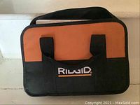Photo of Rigid branded soft carrying case in orange and black with handle.