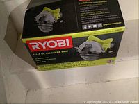 Photo of the Ryobi circular saw in its original box showing brand, model size, and key specs such as 7-1/4 inch blade, 13 amp, 5000 RPM, lightweight.