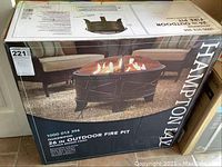 Boxed Hampton Bay 26 inch outdoor fire pit showing product photo and branding.