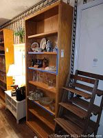 Front view of tall wooden bookcase loaded with various decorative items, showing multiple shelves and overall height.