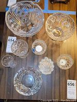 Top view of three bowls and smaller glassware pieces on wooden surface