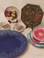 Tea cups with saucers, fruit painted plate, floral octagonal plate, and large blue serving platter