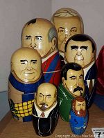 Seven hand-painted wooden nesting dolls of political figures with detailed facial features and attire.