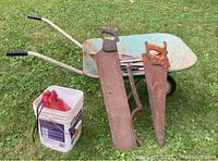 Full lot view showing wheelbarrow, two hand saws, bucket with red rope