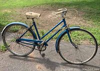 Full side view of blue Robin Hood ladies step-through bicycle showing frame, wheels with metal fenders, and cream colored saddle