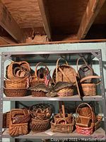 Multiple wicker baskets arranged on metal shelves with a metal eagle wall plaque in front.