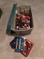 Large plastic storage bin open to show assorted Christmas decorations and ornaments inside