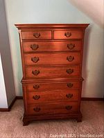 Front view showing overall dresser with eight drawers and ornate metal handles
