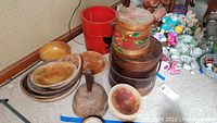 Overview of collection showing red firkin, dough bowls stacked, wooden pestle, and stacked round containers including floral decorated one
