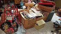 Overall view of lot showing fabric boxes, baskets, metal shoe rack, and sewing tote on floor.