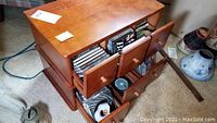Top side view of wooden storage chest with three drawers open, showing CDs stored inside including some loose discs.