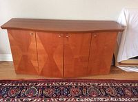 Front view of matte cherry wood buffet showing four doors with geometric paneling and flat top surface.