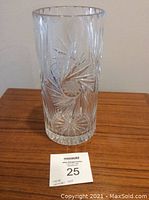 Front view of leaded crystal vase showing starburst cut pattern and cylindrical shape.