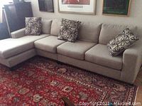 Overall view of the three-piece sectional arranged on rug showing chaise, loveseat, and chair