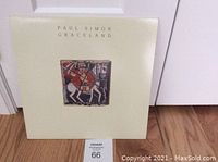 Front cover of Paul Simon Graceland vinyl LP album showing central artwork with stylized figure on a horse and album title above.