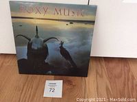 Front cover of the Avalon album by Roxy Music showing helmet and bird image with sunset background