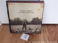 Front view of All Things Must Pass album cover with visible wear and tape.