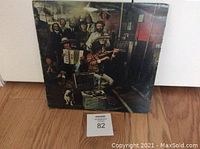 Front cover of album showing Bob Dylan and The Band in a basement setting, holding instruments, and a dog in foreground.