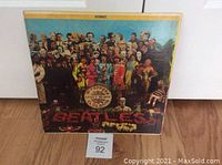 Front cover of Beatles Sgt. Pepper's Lonely Hearts Club Band vinyl LP album, showing group image with white and yellow stripe at top labeled 'STEREO'