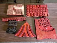 Full view of all seven wooden batik printing blocks showing various shapes and carved patterns.