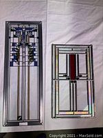 Both stained glass panels laid flat on white cloth, showing overall lot contents