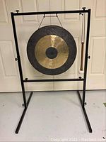 Front view of gong mounted on metal stand with mallet