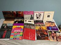 Photo showing 20 LP album front covers laid out on a surface, showing varied artist, album art, and genres.