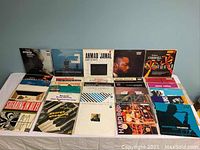 Overhead view of approximately 17 vinyl LPs arranged in three rows