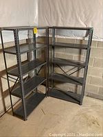 Two metal shelves positioned in basement corner. Show entire shelving units and structure.