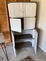 Front view of Rubbermaid outdoor storage cabinet with doors closed or partially open showing two levels
