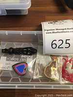 Clear organizer tray with carved black pendant, enamel heart pin, gold-tone Buddha pendant in bag and red cord